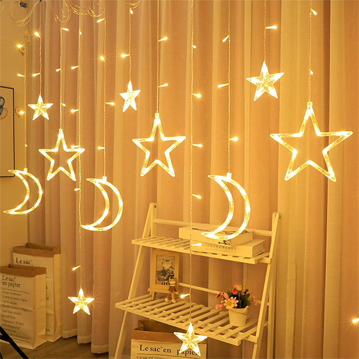String lights with moon and star shapes illuminated, hanging indoors, creating a decorative ambiance.