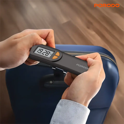 Hands using porodo lifestyle luggage scale to measure suitcase weight before travel Qatar