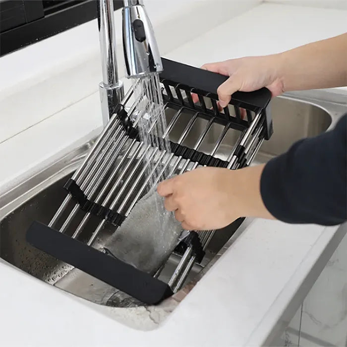 Expandable dish rack being cleaned under running water for easy maintenance in kitchens Homesouq Qatar