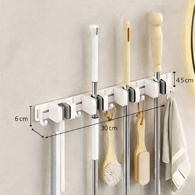 Wall-mounted holder with wall hooks for mop handle storage, compact design keeps cleaning tools organized Qatar