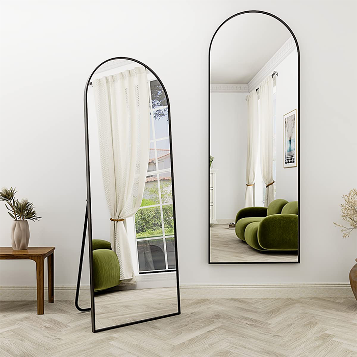 Arched standing mirror with black frame placed in modern living room interior Qatar