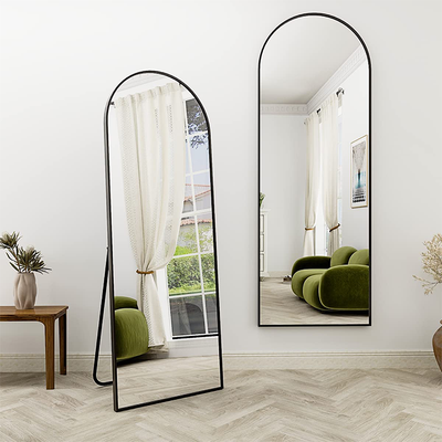 Arched standing mirror with black frame placed in modern living room interior Qatar