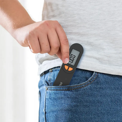 Pocket-size digital luggage scale placed in jeans pocket for easy travel use Qatar