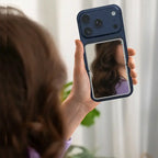 Woman using Green Lion Mirror power bank as vanity mirror on iPhone back panel – Homesouq Qatar