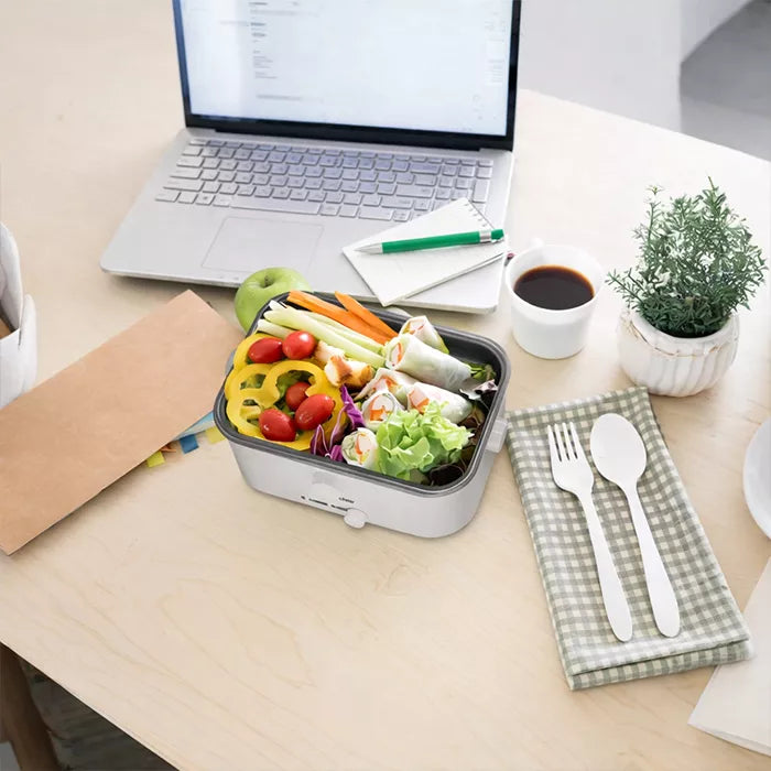 Electric lunch box with fresh vegetables and meal beside laptop and coffee on desk Homesouq Qatar