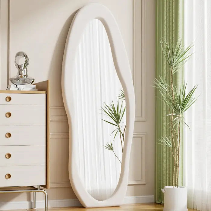 Floor standing oval mirror beside cabinet and plant decor in modern home floor length mirror Homesouq Qatar