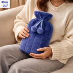 Soft blue hot water bottle with plush cover and pom-pom ties, ideal for soothing aches, warming hands and feet, or use as a cold compress Qatar