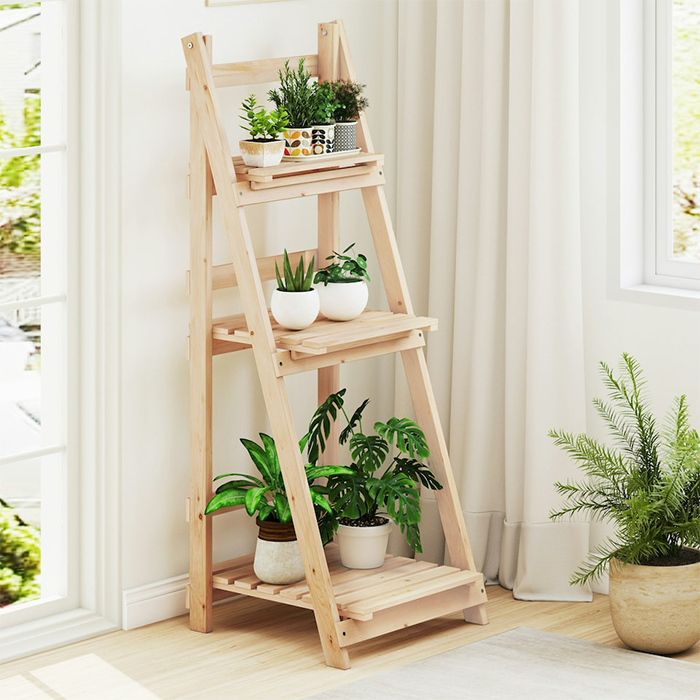Wooden indoor plant stand holding multiple plants near window allowing sunlight exposure in Qatar
